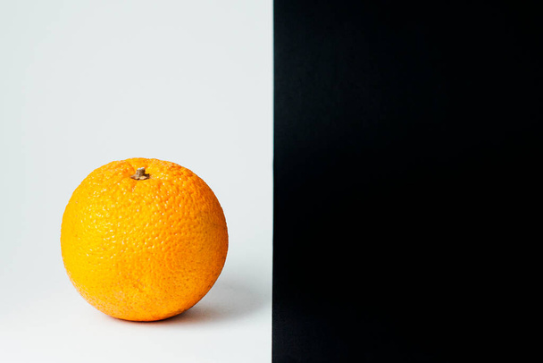 Orange on a black and white background. It stands on a white background. - 写真・画像