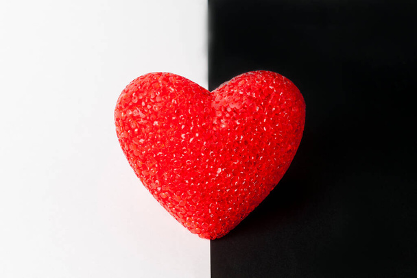 Red heart on black and white background. The heart is in the middle. - Фото, изображение