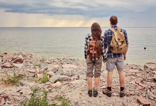 Happy couple with travel backpacks enjoying their summer vacation trip - 写真・画像