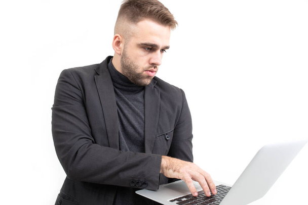 Chlap v obchodním oblečení pracuje na notebooku na bílém pozadí - Fotografie, Obrázek