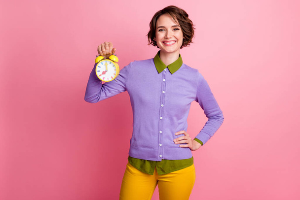 Photo of positive girl hold clock wear outfit isolated over pink color background - Foto, immagini