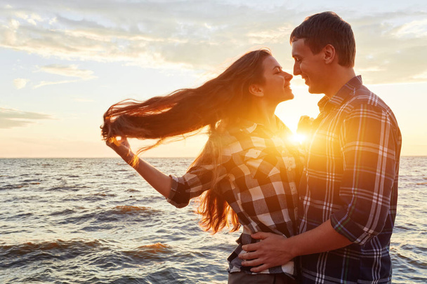 pareja joven divirtiéndose en una costa arenosa - Foto, imagen