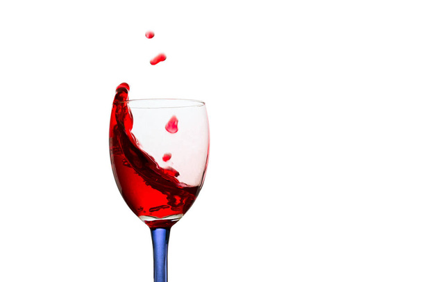 tasty alcoholic drink red wine in a glass with flying up drops looks appetizing on a white background - Foto, immagini