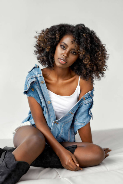 Smiling black girl with afro hairstyle sitting and posing - Valokuva, kuva