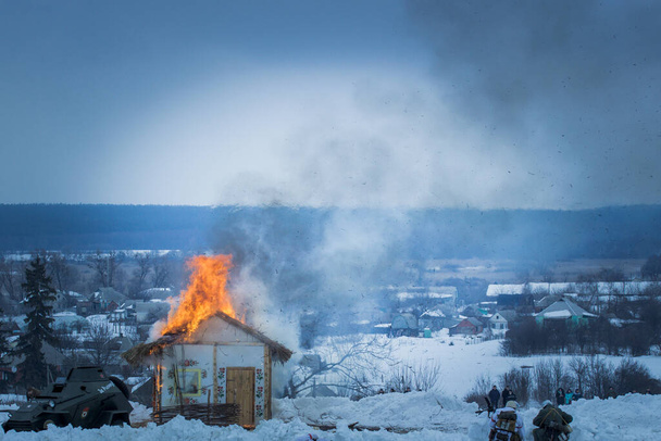 вид горящего деревянного дома в зимнем пейзаже - Фото, изображение