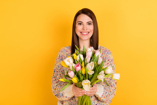 Photo of happy positive young woman hold flowers hands good mood isolated on yellow color background - Foto, immagini