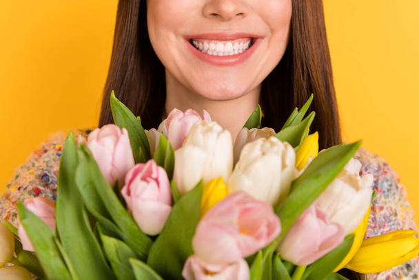 Cropped photo of cheerful young woman smile flowers spring season holiday isolated on yellow color background - Fotografie, Obrázek