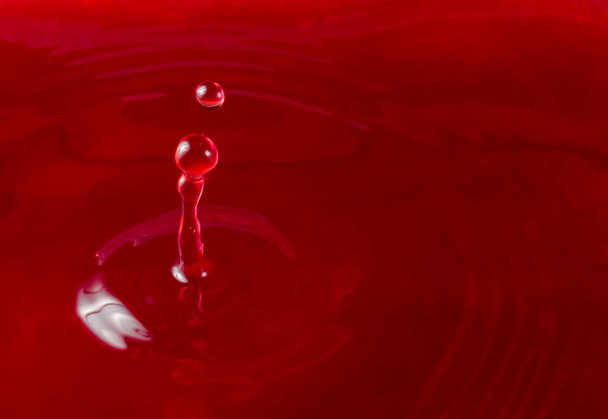 bright drop of red wine falling on the surface of red wine concept of alcoholic beverage - Φωτογραφία, εικόνα