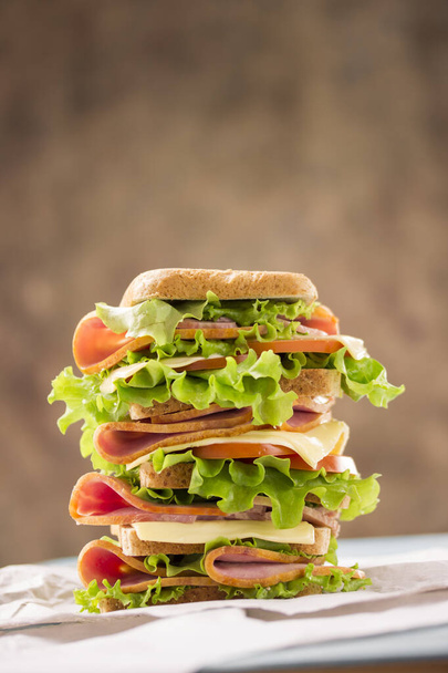 bright appetizing large sandwich with ham cheese and greens shiny and tasty - 写真・画像