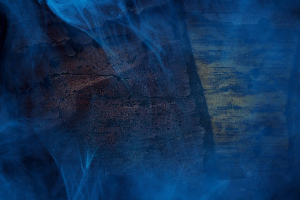 vapor de cigarrillo azul es similar a la niebla que cubre el tronco amarillo-marrón de una naturaleza de pino y halloween concepto de fondo para el diseño - Foto, Imagen