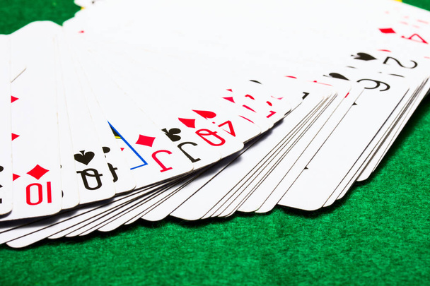 baraja de baraja de fans de jugar a las cartas en un concepto de lona verde brillante de juegos de mesa y casinos - Foto, Imagen