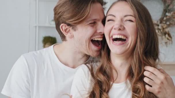 Caucasian millennial happy couple newlyweds married man and woman hugging cuddling sincerely laughing having fun together, boyfriend and girlfriend girl and guy toothy dental smile, family portrait - Footage, Video