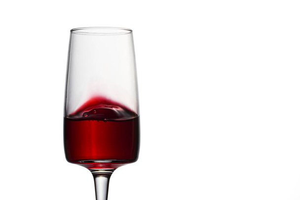red wine brightly splashes in a transparent glass sweet alcoholic drink from grapes - Fotografie, Obrázek
