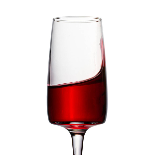 splashing red wine in an elegant glass on a white background a bright alcoholic drink made from grapes looks appetizing - Foto, Imagem