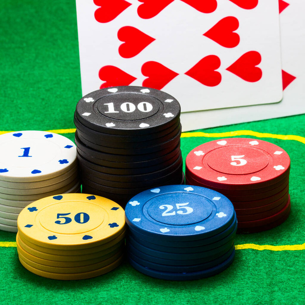columnas multicolores de fichas de póquer en un fondo de un juego de cartas corazones concepto de juegos de azar y casino - Foto, Imagen