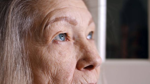Close up portrait of sad senior woman with blue eyes gray hair and wrinkled skin - Φωτογραφία, εικόνα