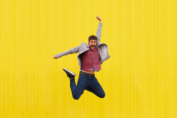 Portret van een vrolijke blanke man die geïsoleerd op een gele achtergrond springt. Hoge kwaliteit foto - Foto, afbeelding