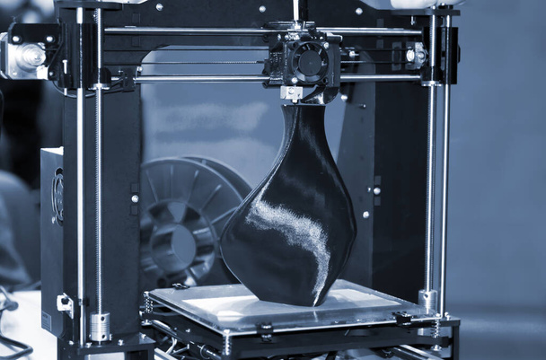 3D tulostin tulostaa mallin muodossa musta maljakko lähikuva. - Valokuva, kuva
