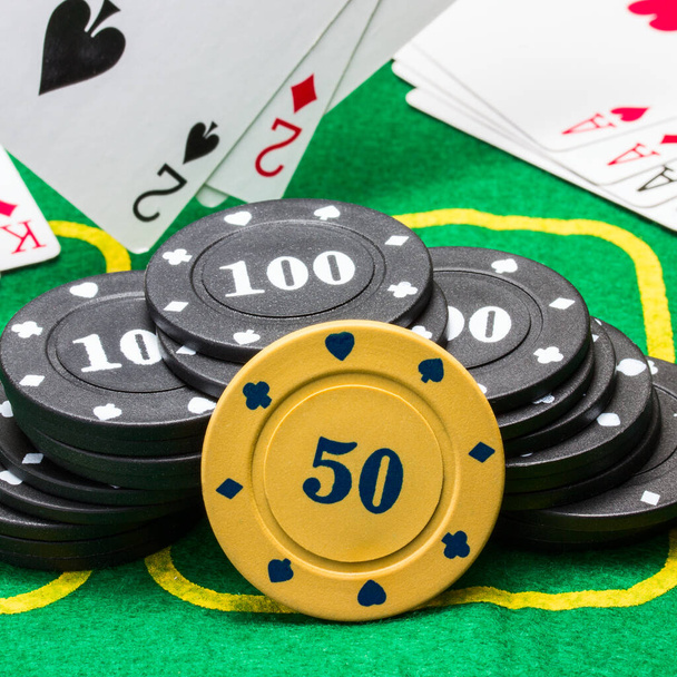 poker chips against the background of falling and lying on the green canvas playing cards concept of business and casino - Photo, Image