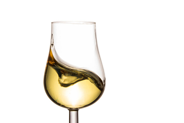 spectacular splash in a glass of white wine on a white background an appetizing alcoholic drink made from grapes - Fotoğraf, Görsel