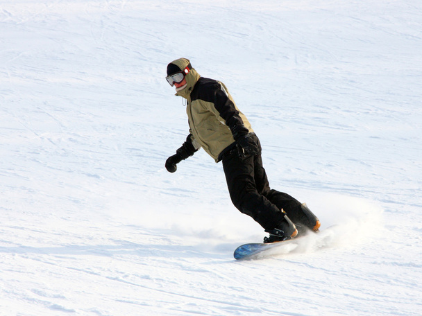 Snowboarder em um terno amarelo que vai da montanha em contra a madeira
 - Foto, Imagem