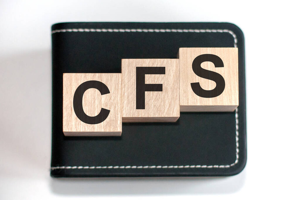 Motivační slova: CFS ve 3D dřevěných abecedních písmenech na pozadí klávesnice s kopírovacím prostorem, obchodní koncept. CFS - zkratka pro konsolidovanou účetní závěrku - Fotografie, Obrázek