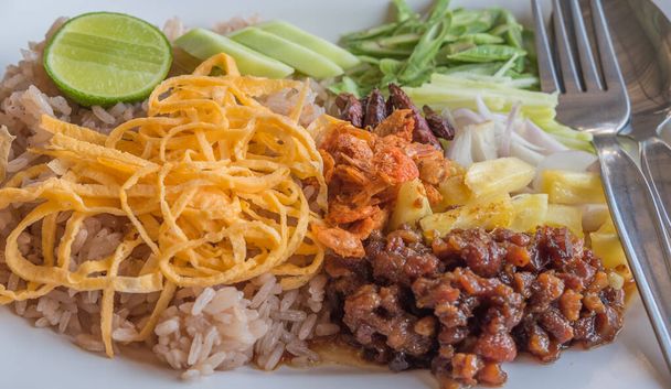 kép Thaiföld street food khao khluk kapi (rizs kevert garnélarák paszta) tetején változatos gyümölcsök és zöldségek - Fotó, kép
