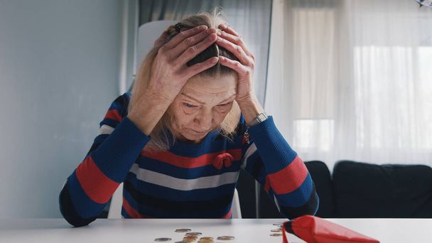 Old retired woman desperately counting coins left. - Photo, Image