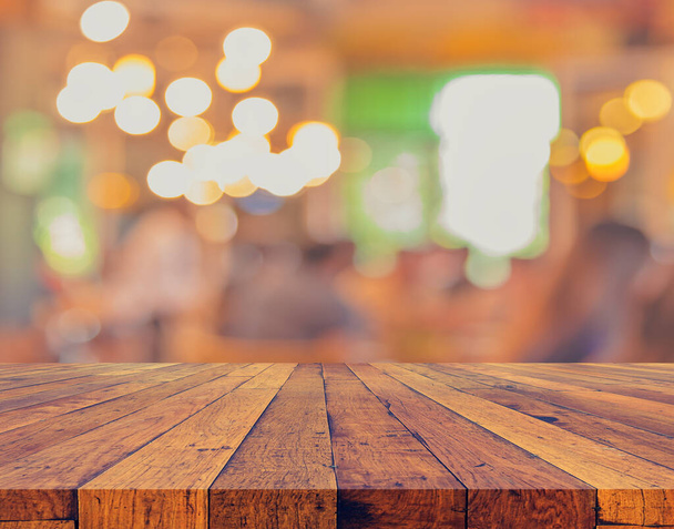 tavolo in legno e Coffee shop sfondo sfocato con immagine bokeh. (tono vintage) - Foto, immagini