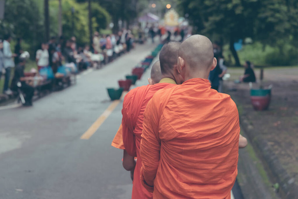image de ton vintage de moine marchant dans la rue le matin avec des gens qui attendent de donner des offres de nourriture - Photo, image
