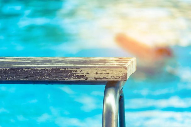 kuva alustan ja hämärtää ihmisiä uima-altaassa. (keskittyminen alustaan) - Valokuva, kuva
