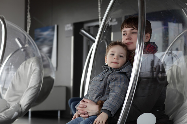 Mother and son relax in glass chair - Foto, Imagem