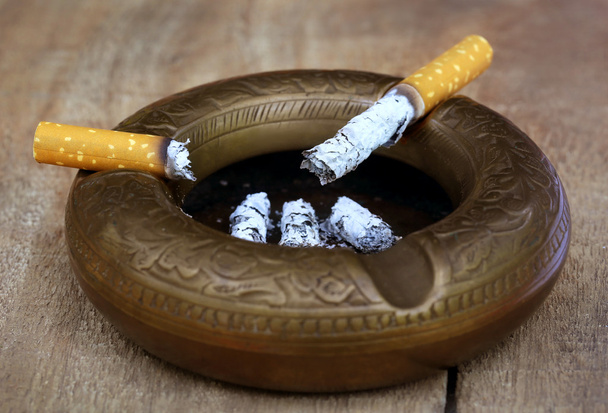 Brennende Zigarette auf einem alten Aschenbecher - Foto, Bild