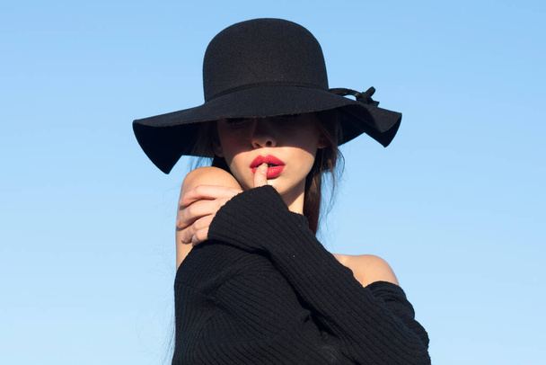Portrait of a young beautiful fashionable woman wearing stylish accessories. Hidden eyes with hat. Romantic model woman with sensual face. Light and shadow. - Foto, Bild