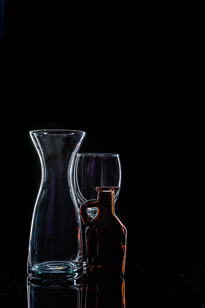 снимок двух разных бутылок и стекла. - Фото, изображение
