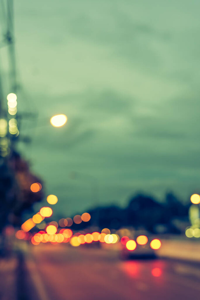 vintage tone image of blur car on road in evening time for background usage.(vertical) - Zdjęcie, obraz