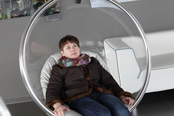 Woman relaxes in glass chair - Foto, Bild