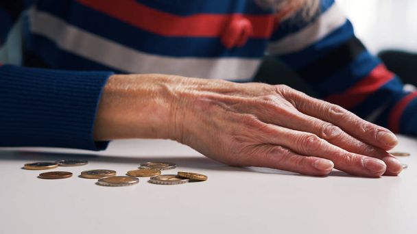 Starsza osoba wkłada pieniądze do portfela. Biedna kobieta nie ma pieniędzy. - Zdjęcie, obraz