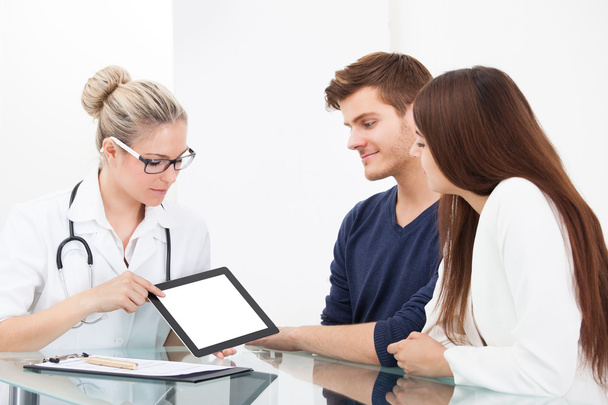 Doctor Showing Report To Couple On Digital Tablet - Photo, Image