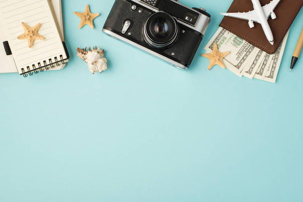 Top view kuva kannettavat kamera kynä kone malli passin kansi dollareita simpukka ja meritähtiä eristetty pastelli sininen tausta tyhjä tila - Valokuva, kuva