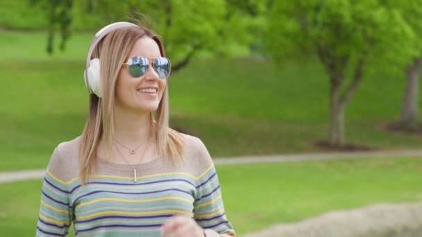 Портрет молодої білявки з навушниками, що слухають музику, RED - Кадри, відео