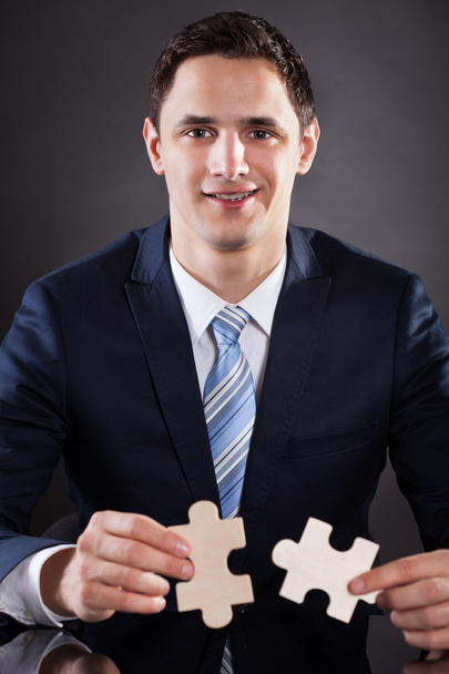 Smiling Businessman Joining Puzzle Pieces - Foto, imagen
