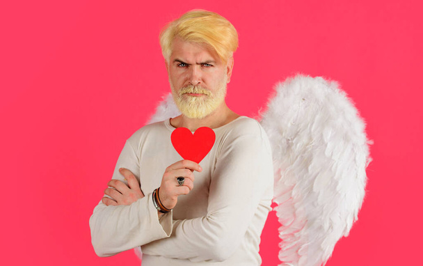 Handsome angel with valentines heart. Cupid man with white wings. Love concept. - Foto, afbeelding