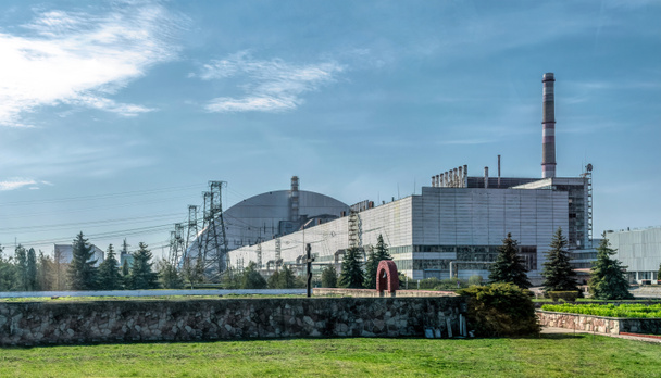  Pripyatin kaupunki, Kiovan alue, Ukraina - 13. huhtikuuta 2019: Tsernobylin ydinvoimalan neljännen hätävoimalaitoksen metallinen hangaarikatos ja Tsernobylin onnettomuuden uhrien muistomerkki - Valokuva, kuva