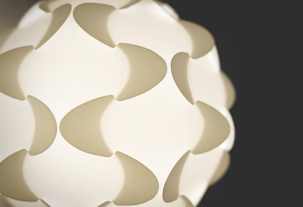 Detail einer weiß beleuchteten Puzzle-Lampe aus den sechziger Jahren mit geometrischen Formen - Foto, Bild