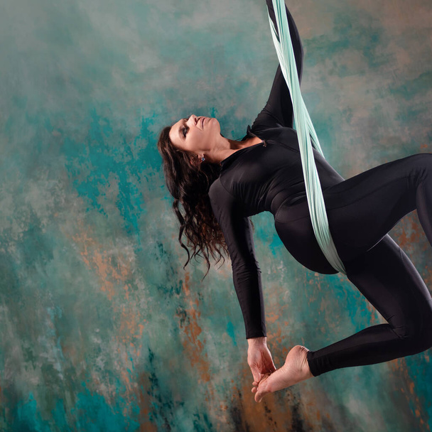 Aero yoga, a young woman doing yoga or stretching on a suspension, - Foto, Imagem