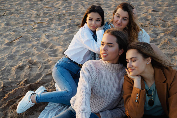 Group of young women in casual outfit on the beach, enjoying the sunset. - Foto, Imagem