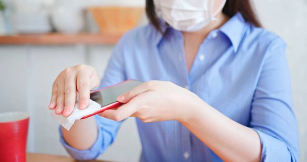 Coronavirus COVID-19 Prevention - woman wiping smartphone on touching surfaces with antibacterial disinfecting wipe for killing corona virus  - Zdjęcie, obraz