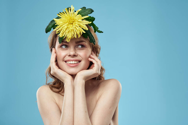 bela mulher com flor amarela perto do rosto sorridente corte vista retrato de ombros desnudados - Foto, Imagem