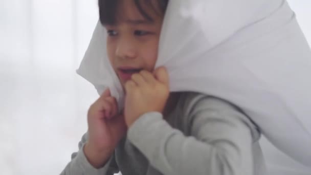 Asiático chico está utilizando almohada para cubrir su ojo y oído de ruido y pesadilla miedo. - Imágenes, Vídeo